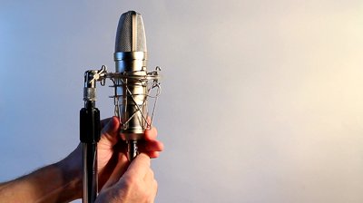 stock-footage-a-closeup-view-of-vocal-condenser-mic-with-man-attaching-mic-cord-white-background-for-text.jpg